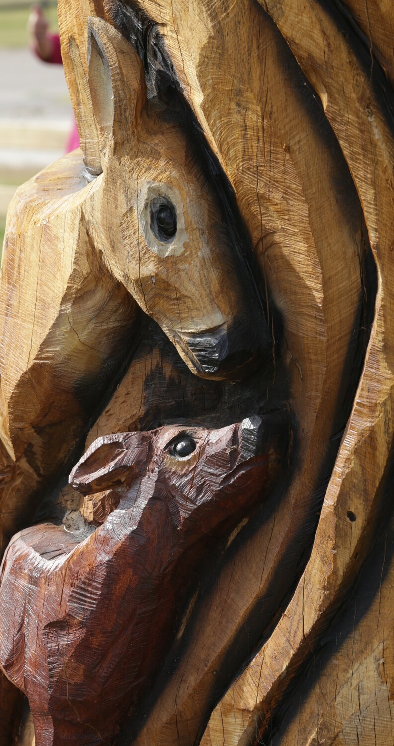 A doe and fawn are among the local wildlife carved into the tree trunk.